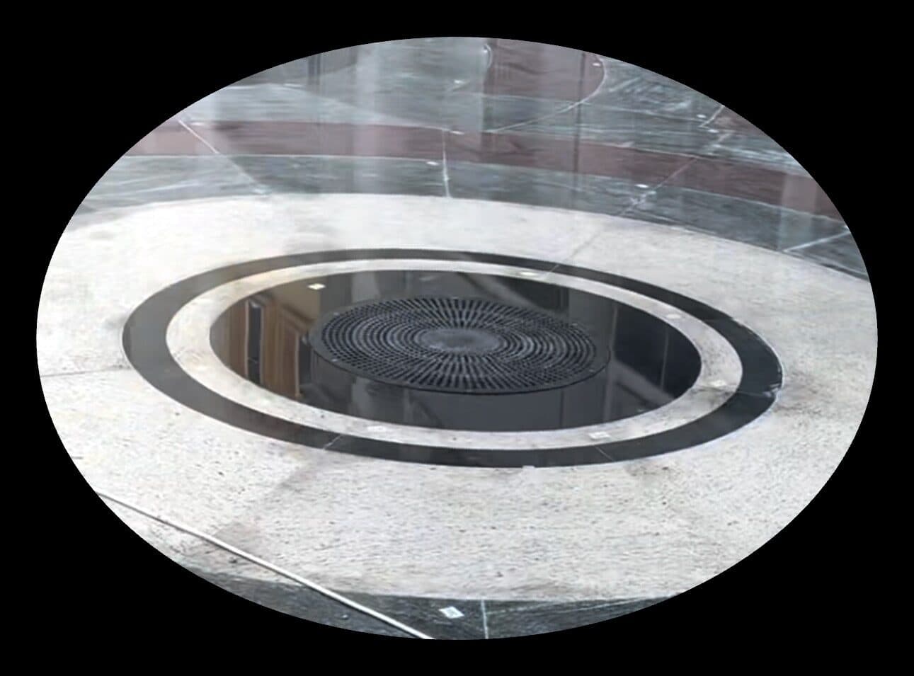 A circular floor grille finished flush in the stone