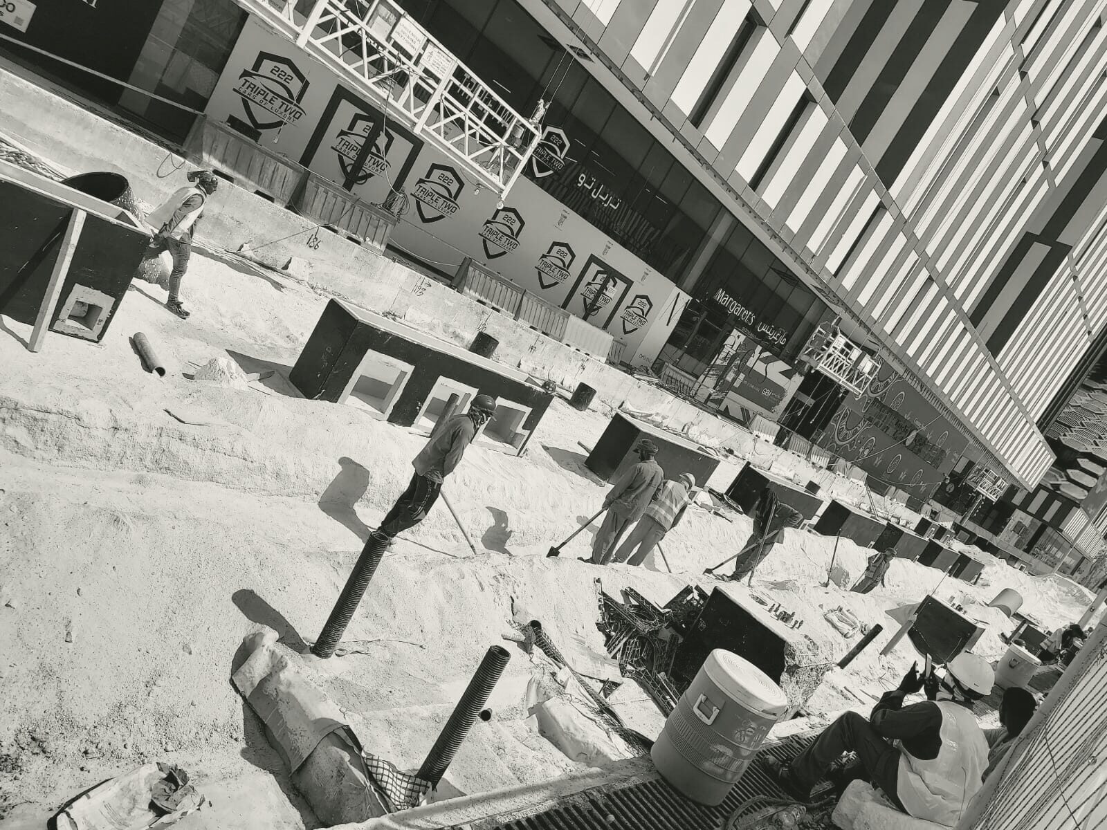 Chilled-water pipework being laid along the boulevard, the Lusail towers behind