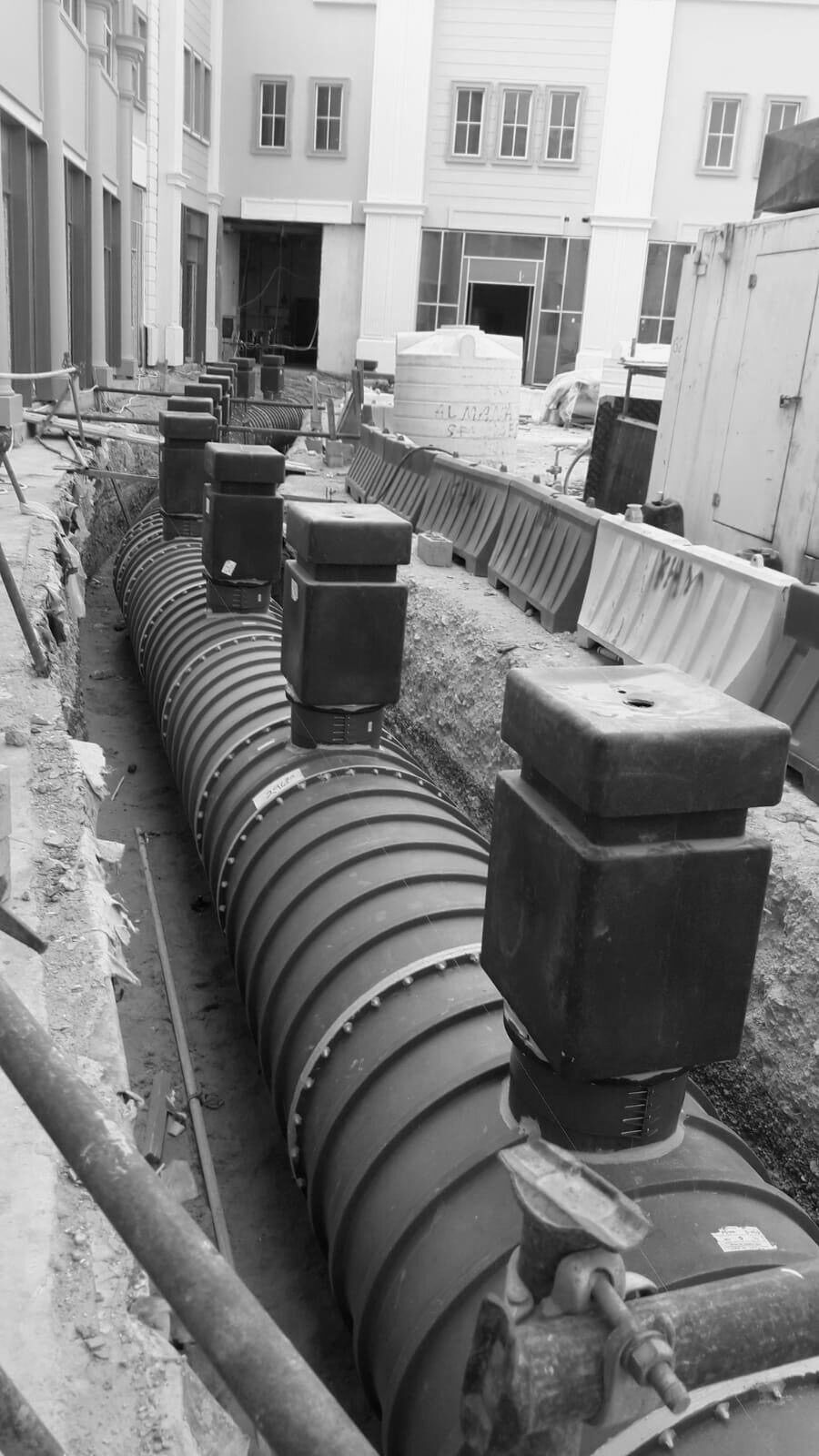 The duct run and its riser boxes in the courtyard trench